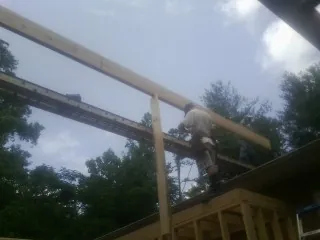Carpenter setting a ridge beam over a new addition frame — Ice Dam Removal by Roofing Brothers in Edwall