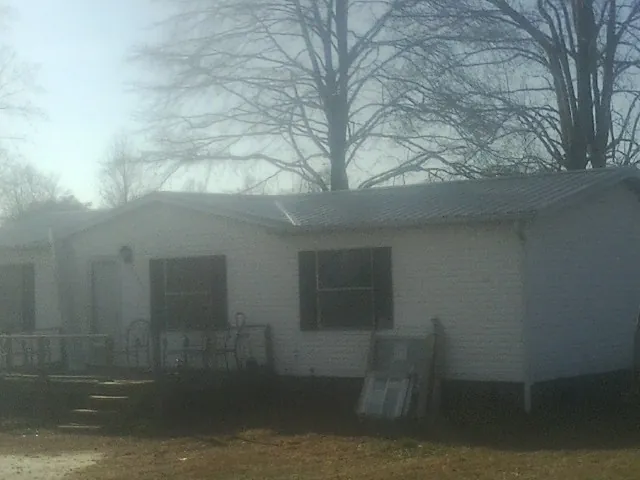 New metal roof on a white painted brick home on a foggy morning in Edwall
