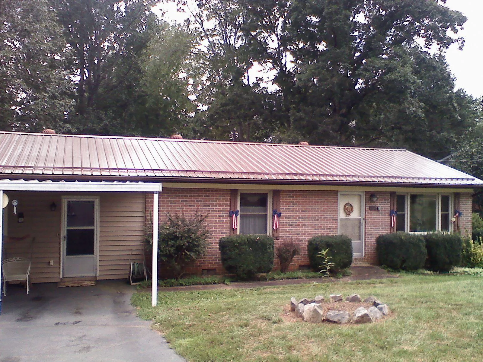 Bronze metal roof and carport on a brick ranch home — Roof Repair work by our crew in Edwall
